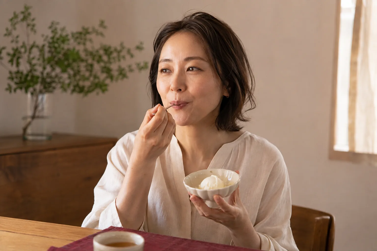 自宅でジェラートをひとすくい味わう女性のイメージ