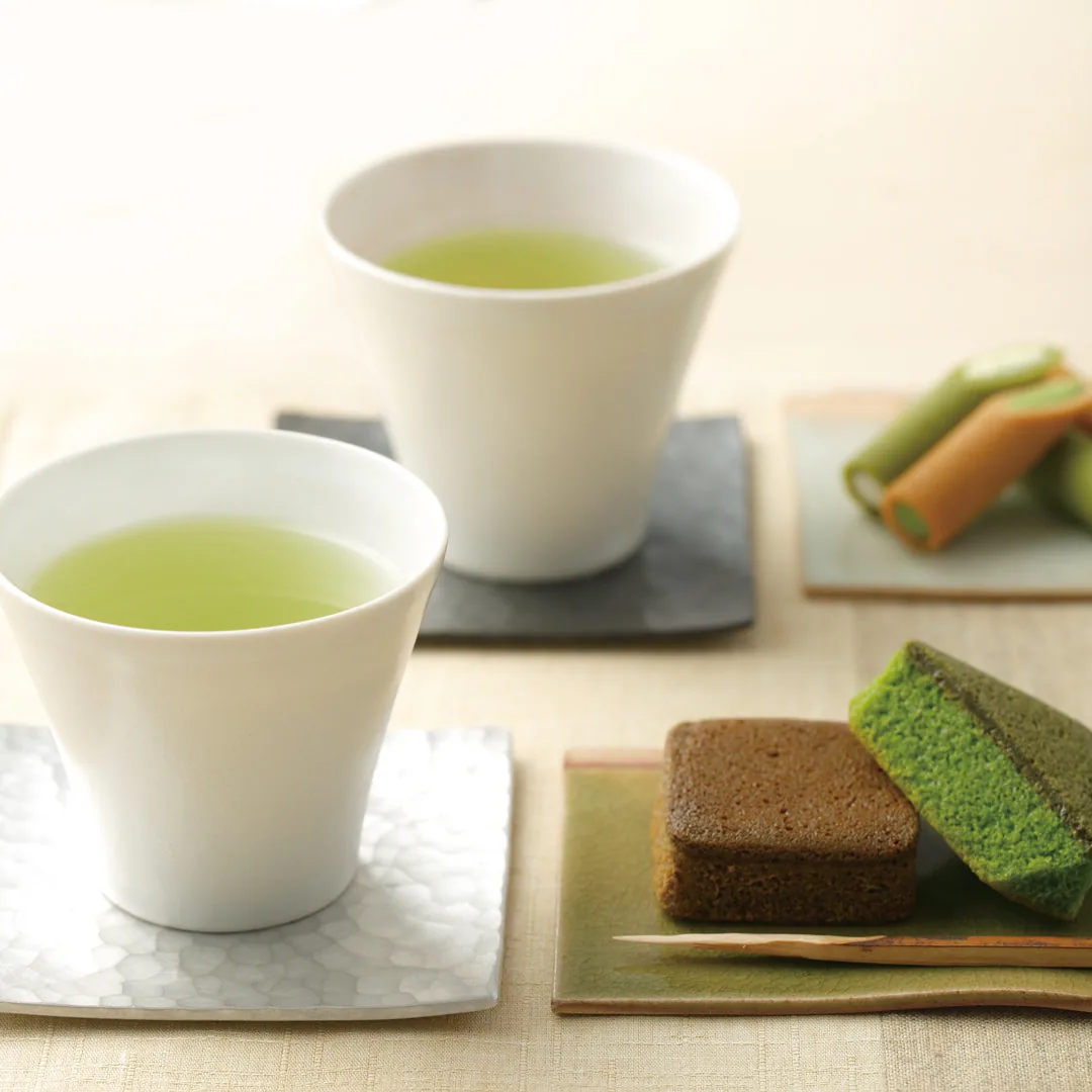 煎茶の湯のみと、抹茶・ほうじ茶フィナンシェ、ロールせんべいを並べた公式のお茶の場面